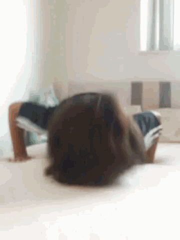 a child is doing a handstand on a bed .