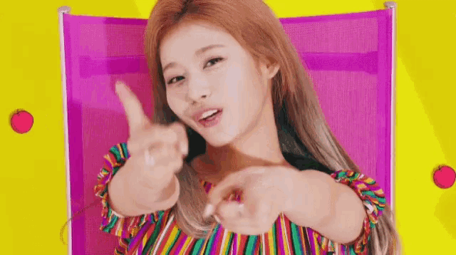 a woman in a striped shirt is giving a thumbs up sign