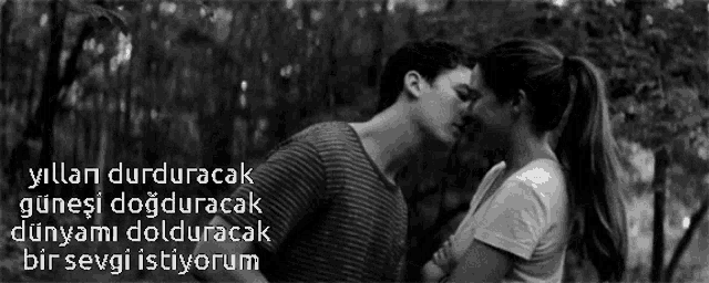 a black and white photo of a man and woman kissing with a caption that says " yillar durduraca "