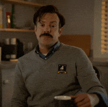 a man with a sweater that says i 'd call you a big dumb poo-poo face