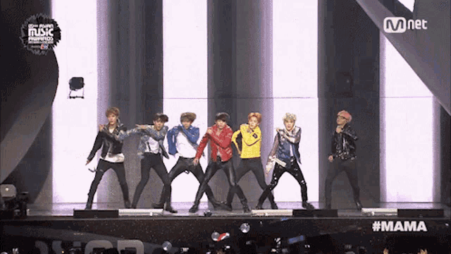 a group of young men are performing on a stage with a mnet logo in the corner