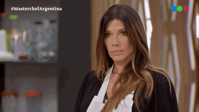 a woman is standing in front of a screen that says #masterchefargentina