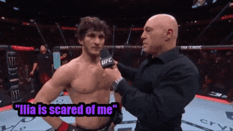 a man talking into a microphone with the words " ilia is scared of me " on the bottom
