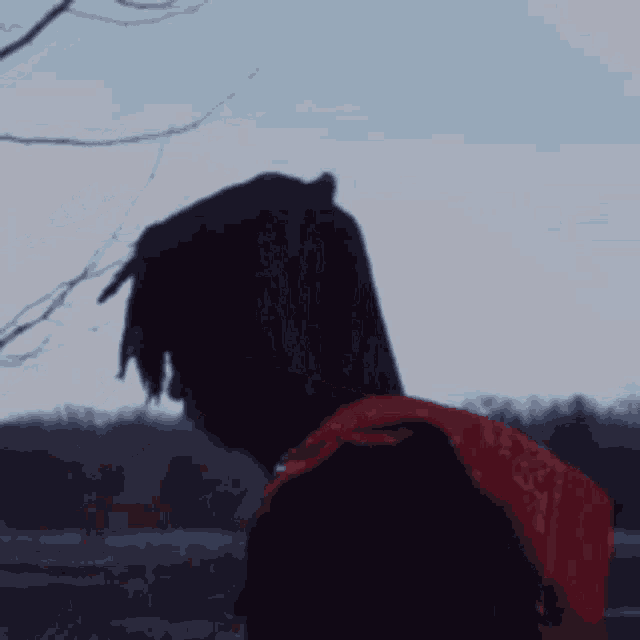 a person wearing a black hoodie with a red strap