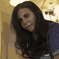 a woman with long hair is wearing headphones and making a face .