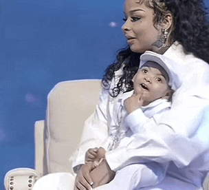 a woman is sitting in a chair holding a baby