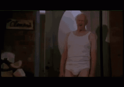 a man in white underwear is standing in a doorway in front of a sign that says ' clown 's '