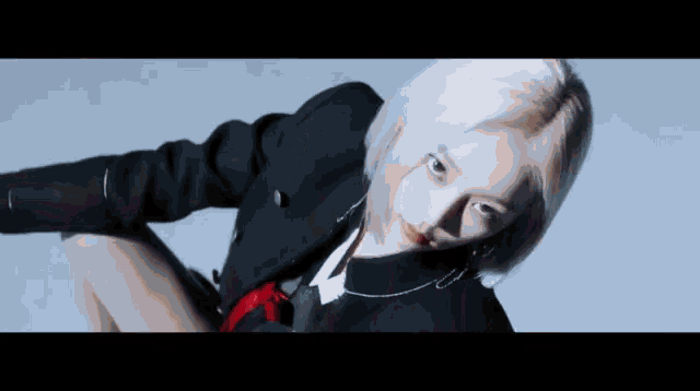 a woman with blonde hair is wearing a black jacket and a red tie