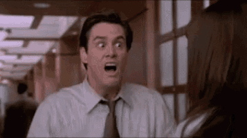 a man in a suit and tie is making a funny face in front of a woman .