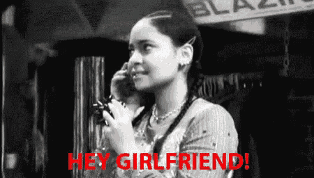 a woman is talking on a cell phone in a black and white photo with the words `` hey girlfriend '' .