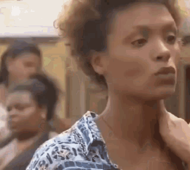 a woman with curly hair is standing in front of a crowd .
