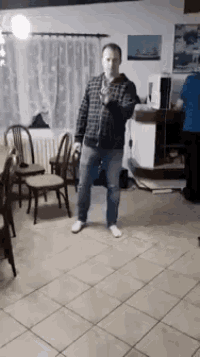 a man is standing in a room holding a microphone .