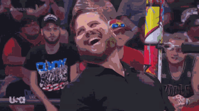 a man in a chicago bulls jersey is laughing in front of a crowd