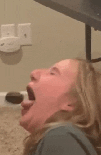 a woman is making a funny face with her mouth open and her tongue out .