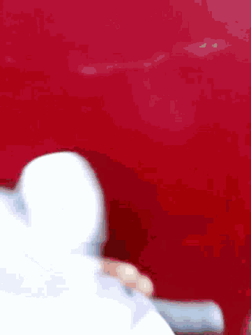 a close up of a person 's hand on a red surface