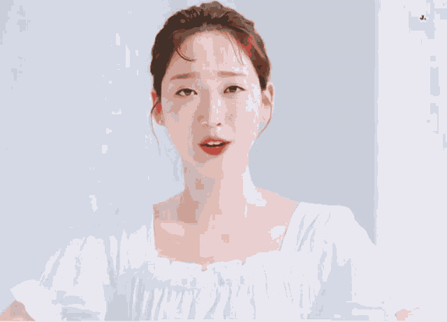 a woman in a white dress is looking at the camera with a white background