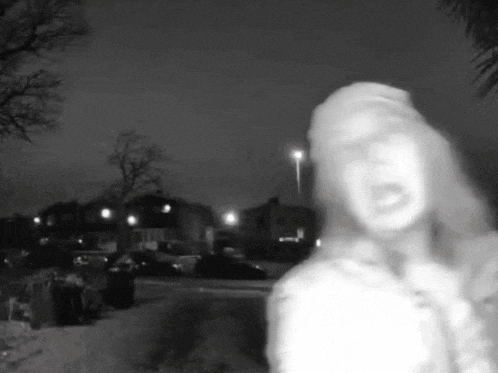 a black and white photo of a woman screaming in a parking lot