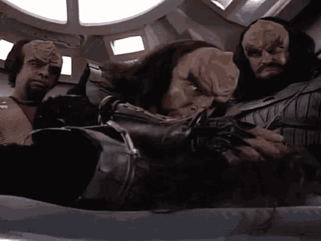 a group of aliens are sitting in a room .