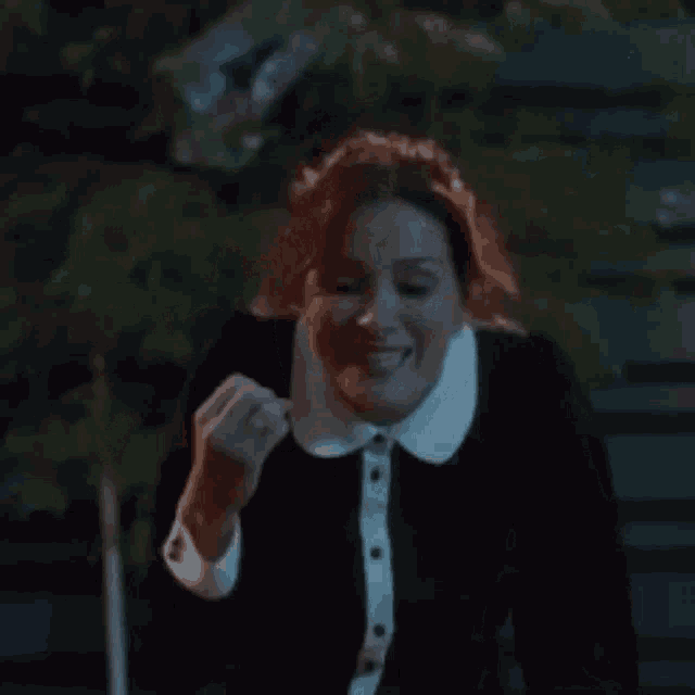 a woman in a black and white collared shirt is screaming