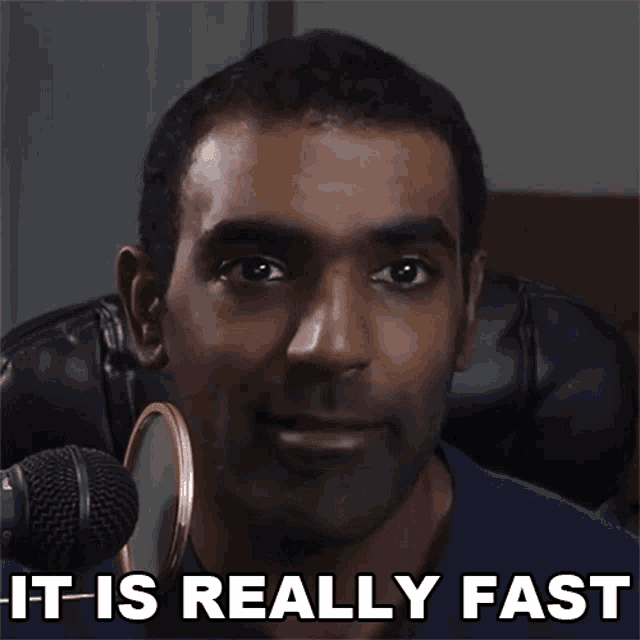 a man sitting in front of a microphone with the words it is really fast above him