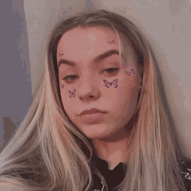 a girl with butterflies on her face has the letter j on her eyebrow