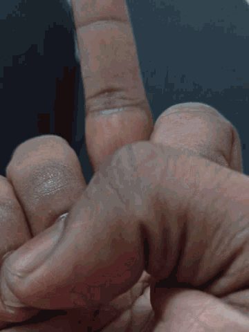 a close up of a person 's hand with the thumb pointing upwards