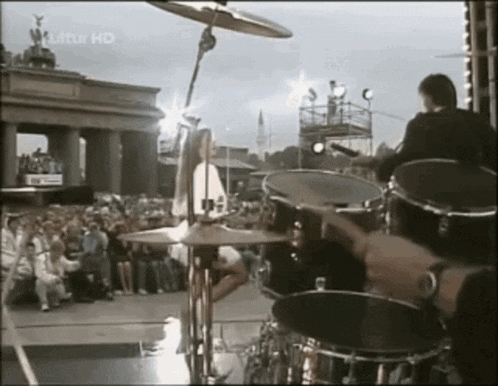 a man playing drums in front of a crowd with luftur hd on the bottom