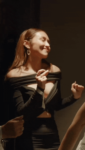 a woman in a black off the shoulder dress is being held by a man