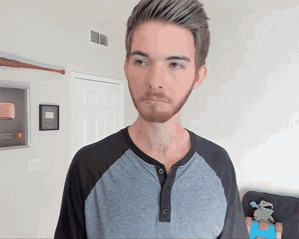 a man with a beard wearing a grey shirt