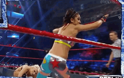 a woman is standing in a wrestling ring with a referee .