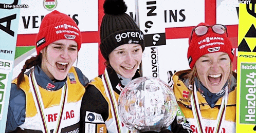 three female athletes are posing for a picture and one of them has a goren hat on