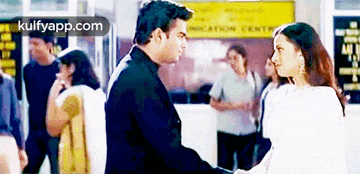 a man and a woman are standing next to each other in a crowded area .