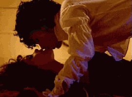 a man in a white shirt is kissing a woman