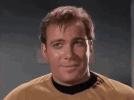 a man is wearing a yellow shirt and a black collar and smiling .