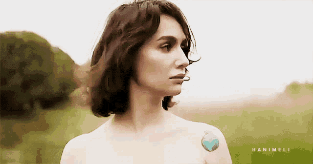 a naked woman with a blue heart tattoo on her shoulder has the name hanimeli on the bottom