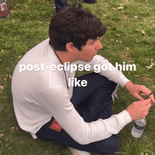 a man sitting on the grass with the words post-eclipse got him like on the bottom