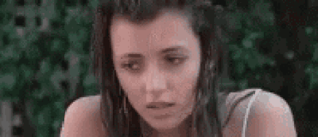 a close up of a woman 's face with a blurred background of trees .