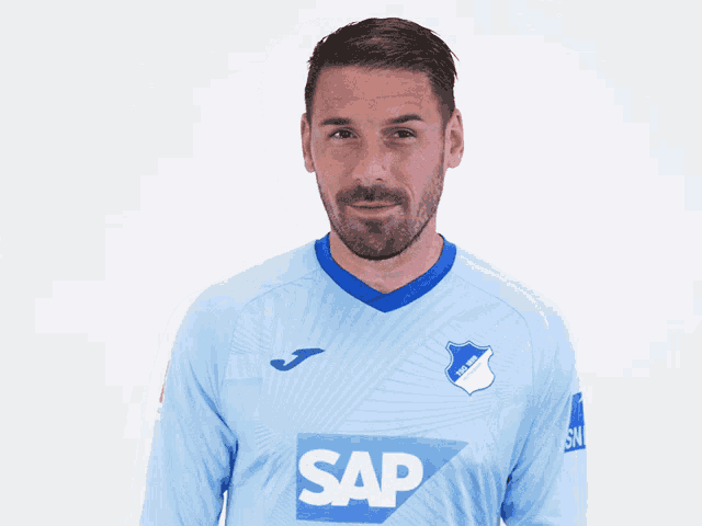 a man is wearing a light blue shirt with the word sap on it