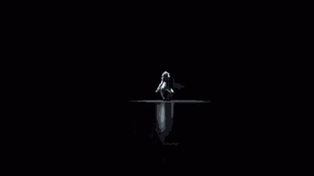 a man with blue hair and a white shirt is dancing in the dark .