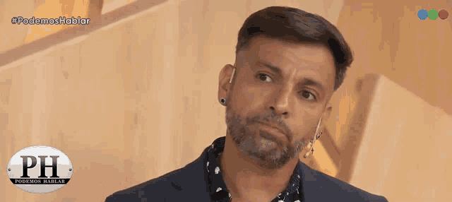 a man with a beard and ear piercings is appearing on a television show called podemos hablar