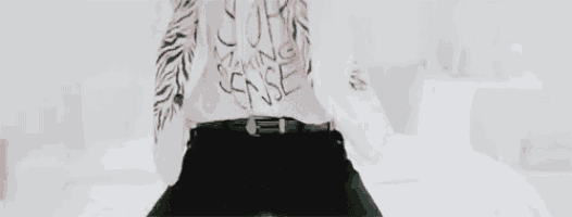 a man with tattoos on his arms and chest is standing in a room .