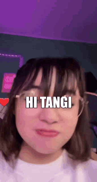 a girl wearing glasses and a white shirt says hi tangi on her face
