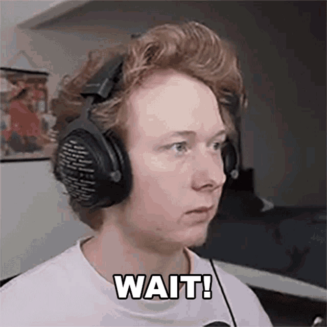 a young man wearing headphones and a white shirt says wait .