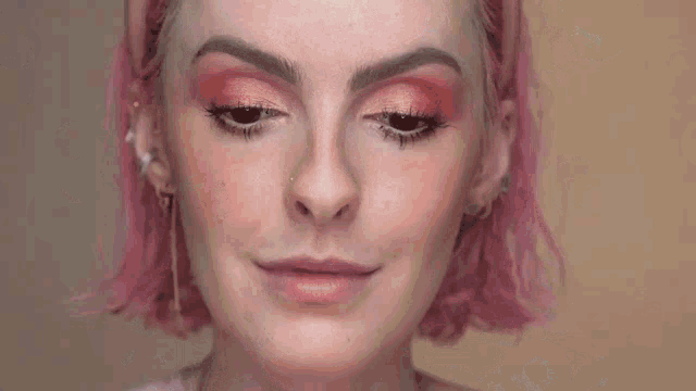 a woman with pink hair is surrounded by soap bubbles
