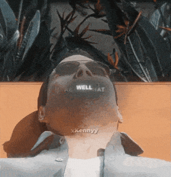 a man wearing sunglasses is laying on a bench with the words well pat written on his face