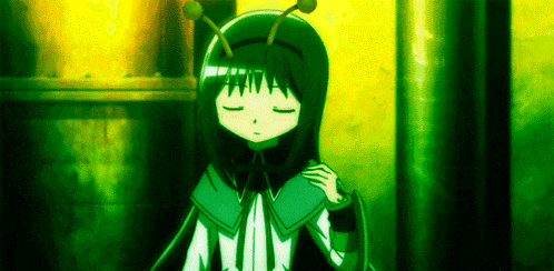 a girl in a green costume with antennas on her head is sitting down with her eyes closed