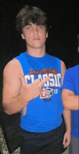 a young man wearing a blue tank top that says phil mcnally classic on it
