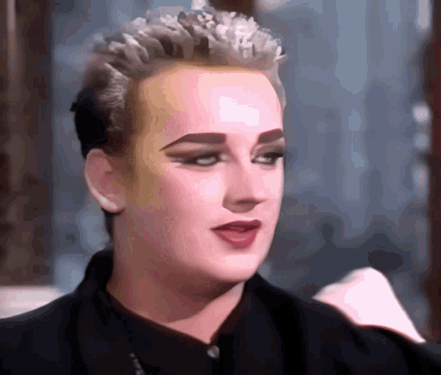 a close up of a person 's face with a black jacket on