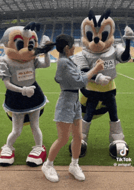 a woman standing next to two mascots one of whom has a shirt that says kirin on it