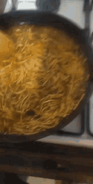 a frying pan filled with noodles and cheese on a stove top